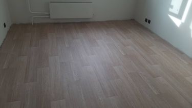 На ровное основание уложено покрытие, тщательно подогнаны стыки, обеспечена ровная поверхность без дефектов, материал аккуратно закреплён по периметру, завершены отделочные работы.