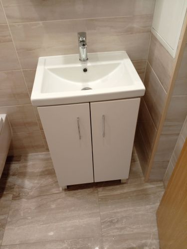 Установлена раковина с тумбой, подключен смеситель, выполнена герметизация швов, проверена работоспособность системы водоснабжения и слива, обеспечена устойчивость конструкции.