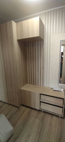 Установлена деревянная полка в прихожей. Закреплена над шкафом, обеспечивая устойчивость и ровность. Подобран цвет под интерьер, что создает гармонию и завершенность обстановки.