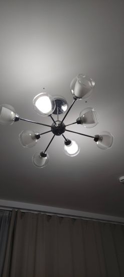 Закреплена новая люстра на потолке, подключены провода, проверена работа освещения, установлены декоративные элементы, обеспечена надежная фиксация конструкции.