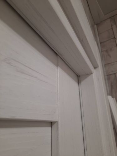 Установлена светлая деревянная дверь, произведен монтаж коробки, закреплены петли, вставлен замок, отрегулированы зазоры, проверена плавность открывания, завершены отделочные работы.