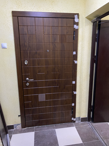 Установлена новая металлическая дверь с декоративной отделкой, закреплены петли, вмонтированы замки, отрегулирована плотность прилегания, завершена отделка откосов, обеспечена надежная фиксация.