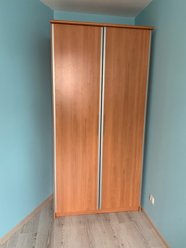 Собран шкаф с раздвижными дверями, установлен в угол комнаты, закреплён к стене. Проведена регулировка дверей, проверена устойчивость конструкции, обеспечена плавность хода.