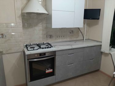 Установлены шкафы, закреплена столешница из искусственного камня, подключена варочная панель и духовой шкаф, смонтирована вытяжка, проведены коммуникации, завершена отделка фартука.