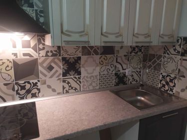 Выполнена установка столешницы с вырезом под мойку и плиту, обеспечивающая точное прилегание к стене. Поверхность аккуратно обработана, создавая гармоничный вид кухни.