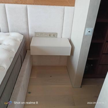 Установлена настенная тумба, закреплены розетки, выполнена обшивка стен мягкими панелями, уложен деревянный пол, смонтирован выключатель.