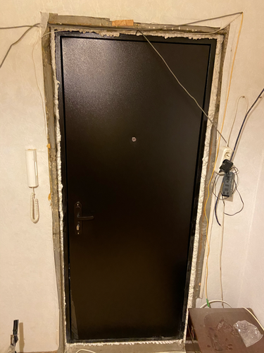 Изображена металлическая дверь, обшитая панелями из МДФ. Завершены работы по установке декоративного покрытия, улучшено внешнее оформление, обеспечена дополнительная звукоизоляция.