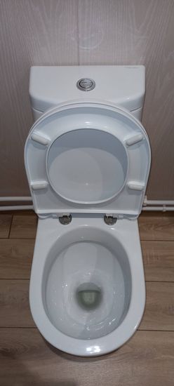 Установлено сантехническое оборудование на полу, подключено к водопроводу, выполнено закрепление, проверена герметичность соединений, произведена регулировка крышки и бачка, завершены все работы.