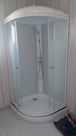 Установлена современная душевая конструкция с низким основанием. Смонтированы стеклянные панели, подключены водопроводные элементы, герметизированы швы, проверена функциональность.