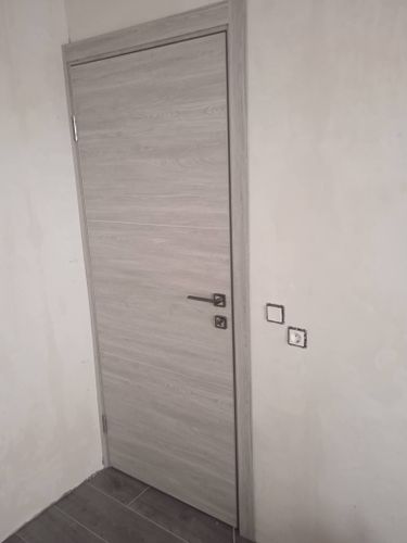 Установлен замок в деревянную дверь. Выполнены точные вырезы, закреплены ручки, механизм функционирует безупречно. Дверь закрывается плавно, обеспечивая надежность и комфорт.