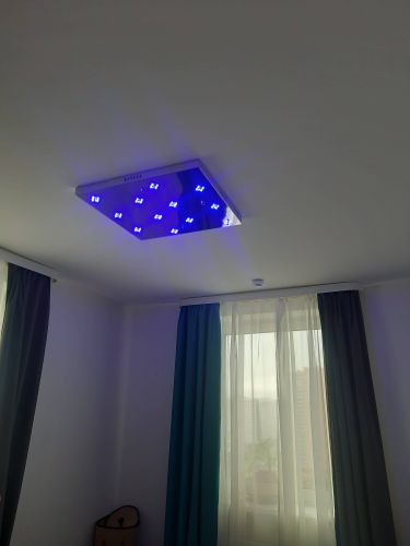 Установлен потолочный светильник с синим свечением. Закреплен на поверхности, подключен к электросети, проверена работоспособность. Завершено оформление интерьера.