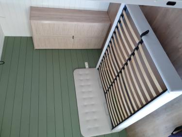 Собран шкаф с дверцами, установлен каркас кровати с ламелями. Все элементы надежно закреплены, обеспечивая устойчивость и функциональность мебели в интерьере.