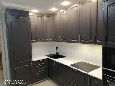 Установлена белоснежная поверхность, идеально подогнанная к кухонным шкафам, с вырезами под мойку и варочную панель. Все швы аккуратно заделаны, обеспечивая гладкость и долговечность.