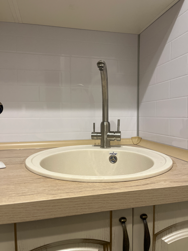 Установлены шкафы, закреплена столешница, смонтирована мойка, подключен смеситель. Завершена укладка фартука из плитки. Все элементы собраны и установлены на свои места.