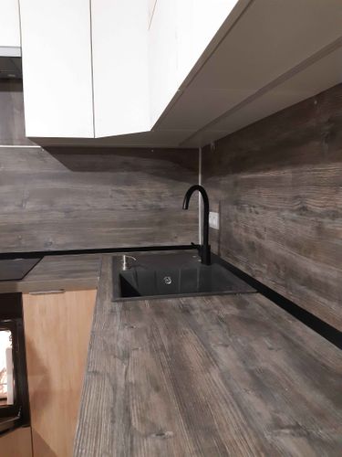 Выполнена точная подгонка кухонной поверхности, установлена мойка, вырезаны отверстия для техники. Столешница аккуратно интегрирована в интерьер, обеспечивая функциональность и стиль.