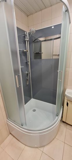 Установлена конструкция с низким основанием, закреплены стенки, подключены водопроводные элементы, проверена герметичность соединений, смонтированы двери, завершена настройка системы.