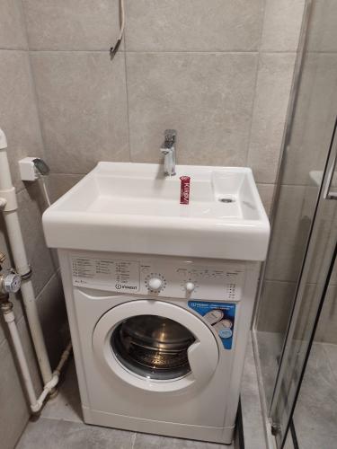 Установлена раковина над стиральной машиной, подключены водопровод и слив, закреплён смеситель, проверена герметичность соединений, обеспечена функциональность и удобство использования.