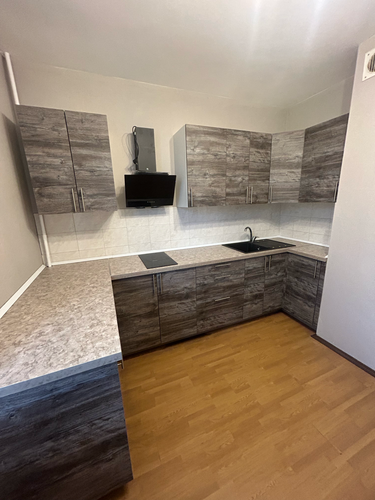 Установлены шкафы, закреплены фасады, смонтирована столешница, подключена варочная поверхность, вмонтирована мойка, установлена вытяжка. Все элементы аккуратно подогнаны и выровнены.