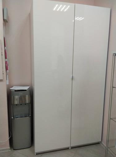 Собран белый шкаф: установлены двери, закреплены полки, прикручены ручки. Конструкция устойчива, элементы подогнаны точно, обеспечена функциональность и эстетичный вид.