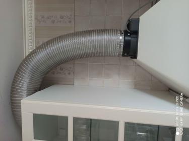 Установлен гибкий воздуховод для вытяжки, соединяющий кухонный шкаф с вентиляционной системой. Труба надежно закреплена, обеспечивая эффективное удаление воздуха.