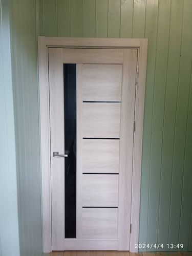 Установлена новая деревянная дверь с одной створкой, закреплены петли, врезан замок, смонтирована ручка, отрегулирована конструкция, обеспечена плавная работа, завершена отделка проема.