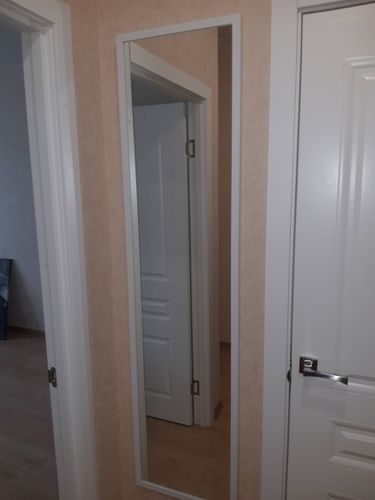 Изображение показывает завершённую работу: ковер надежно закреплен на стене, создавая уютную атмосферу в интерьере. Стены и пол гармонично сочетаются с текстильным элементом.