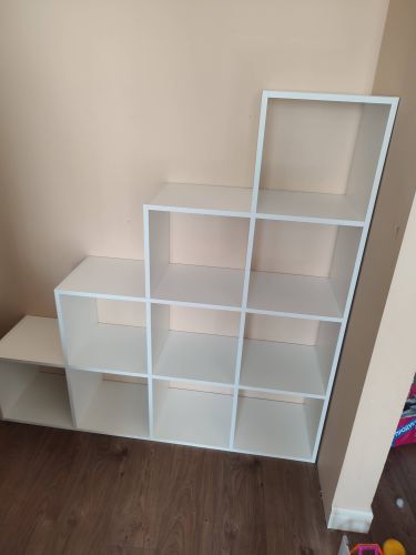 Собрано изделие с девятью квадратными секциями, установлено на ровный пол у стены. Все элементы надежно закреплены, конструкция устойчива и готова к использованию.