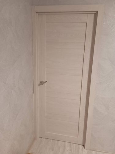 Выполнена установка запорного механизма в деревянное полотно. Проведены работы по вырезанию отверстия, закреплению ручки и проверке функционирования. Все элементы надежно зафиксированы.