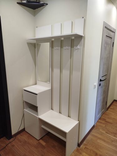 Собрана мебель: установлены полки, закреплены крючки, смонтировано зеркало, собран шкаф с ящиками и скамейка. Все элементы надежно зафиксированы, обеспечивая функциональность.