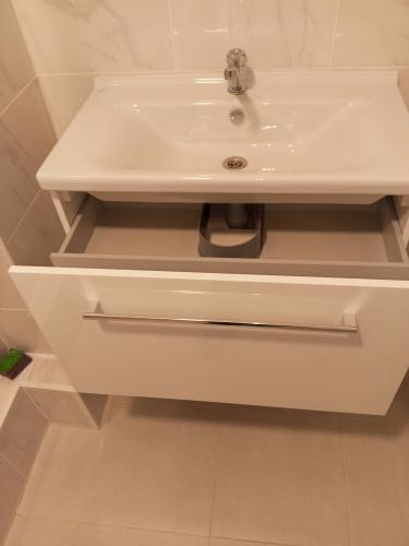 Установлена раковина с подключением к водопроводу и канализации, закреплен смеситель, обеспечена герметичность соединений, проверена функциональность системы, выполнена чистовая отделка.