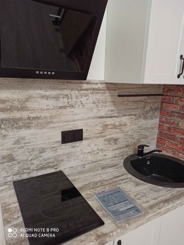 Отрезана и установлена столешница на кухне. Выполнены вырезы для варочной панели и мойки. Поверхность аккуратно подогнана под размеры, обеспечена точная подгонка и чистота линий.