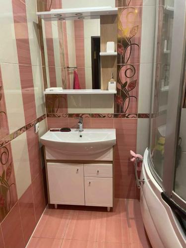 Зеркало надежно закреплено на стене ванной комнаты над раковиной. Установлены полки для удобства хранения. Работа выполнена аккуратно, без видимых дефектов, с учетом дизайна интерьера.