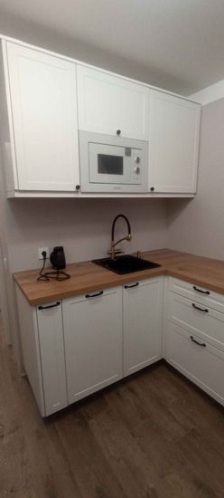 Установлены шкафы, закреплены фасады, смонтирована столешница, врезана мойка, подключен смеситель, встроена техника, установлены ручки, проведены коммуникации.