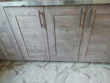 Изготовлены и установлены деревянные панели для кухонных шкафов. Выполнены точные разрезы, обеспечивающие идеальную подгонку и гладкую поверхность. Установлены стильные металлические ручки.