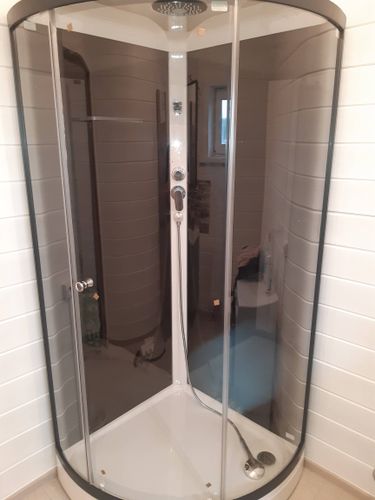 Установлена современная душевая кабина с прозрачными дверями, заменены коммуникации, обновлены стены, проведена герметизация, подключено водоснабжение, проверена функциональность.