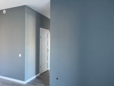 Стены покрыты ровным слоем краски, создавая гладкую, матовую поверхность. Цвет равномерно распределен, без потеков и пятен, обеспечивая свежий, обновленный вид помещения.