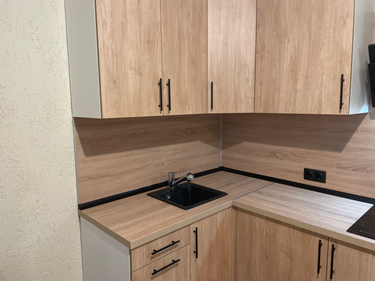 Проведена работа по точной подгонке и установке кухонной поверхности, включая вырез под мойку и плиту, с аккуратной обработкой краев и стыков для идеального прилегания.