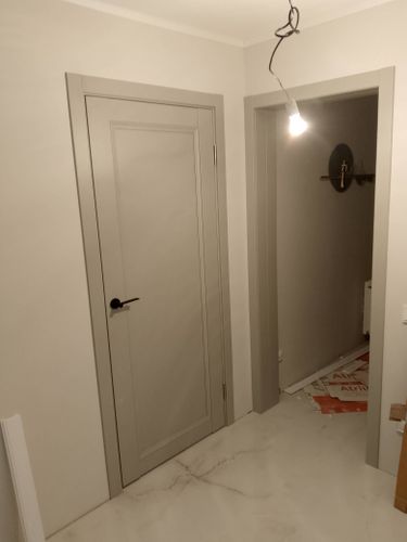 Изображена установленная дверь-гармошка, аккуратно вмонтированная в проем. Завершены работы по фиксации направляющих, креплению полотна и регулировке механизма.