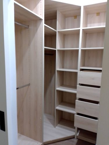 Установлены полки в шкафу, обеспечивая дополнительное место для хранения. Конструкция выполнена из светлого дерева, что придаёт интерьеру аккуратный и современный вид.