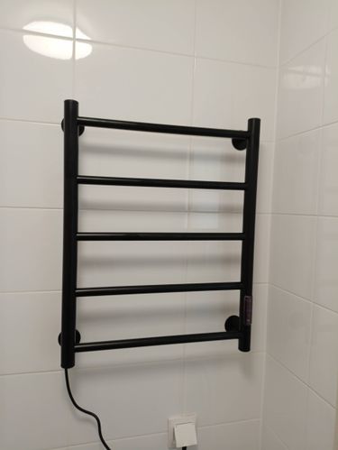 Установлено устройство для сушки полотенец на стене, подключено к электросети, проверена работоспособность, закреплено надёжно, обеспечена безопасность эксплуатации.