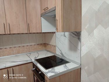 Установлены шкафы, закреплены фасады, смонтирована столешница из искусственного камня, встроена варочная поверхность, закреплены ручки, выполнена отделка стен плиткой.