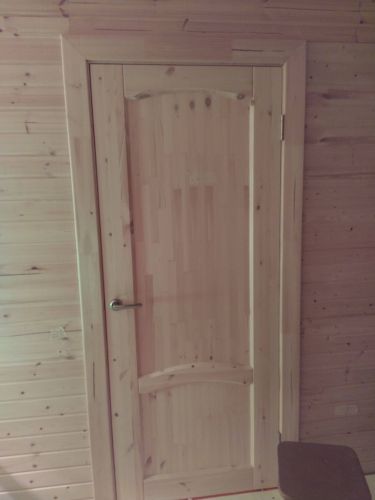 Установлена деревянная дверь, закреплены петли, врезана ручка, отрегулировано полотно, обеспечена плавная работа, проверено прилегание, завершена отделка наличниками.