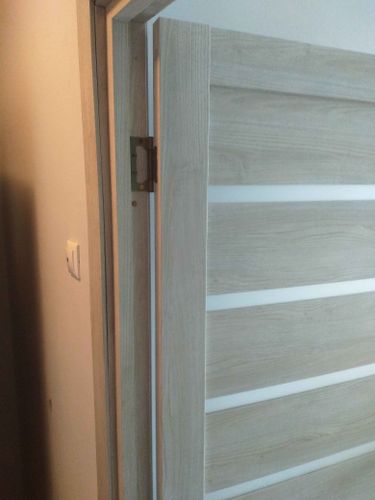 Установлены деревянные доборы на проем, обеспечивая плавный переход между стеной и дверью. Все элементы плотно подогнаны, создавая аккуратный и завершенный вид.