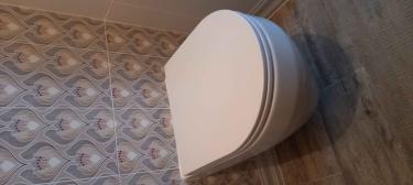 Закреплена конструкция для подвесного унитаза, подключены коммуникации, установлена чаша, выполнена облицовка плиткой. Все элементы надежно зафиксированы, система готова к эксплуатации.