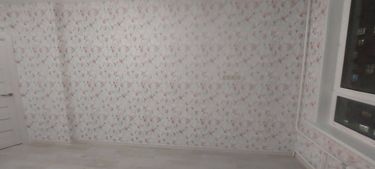 На стенах аккуратно наклеены фотообои с нежным цветочным узором, создавая гармоничную атмосферу. Все стыки ровные, без видимых дефектов, поверхность гладкая и чистая.