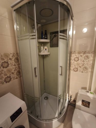 Установлена современная душевая конструкция с герметичными дверцами, подключены водопровод и слив, проверена работа смесителя и душевой лейки, закреплены полки для аксессуаров.