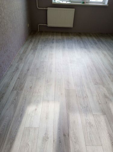 На ровное основание аккуратно уложен линолеум, обеспечивая безупречную гладкость и ровность покрытия. Швы тщательно подогнаны, создавая цельный и эстетичный вид пола.