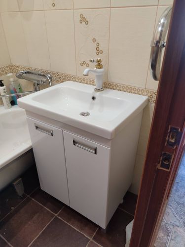 Установлена раковина с тумбой, подключены водопроводные трубы, закреплен смеситель, герметизированы стыки, проверена герметичность соединений, обеспечена функциональность.