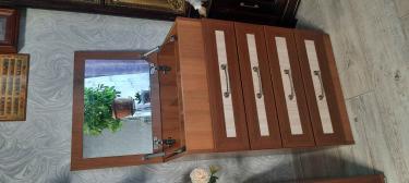 Собран комод с зеркалом и четырьмя выдвижными ящиками. Установлены ручки, закреплены петли. Все элементы надежно зафиксированы, обеспечивая функциональность и эстетичный вид.