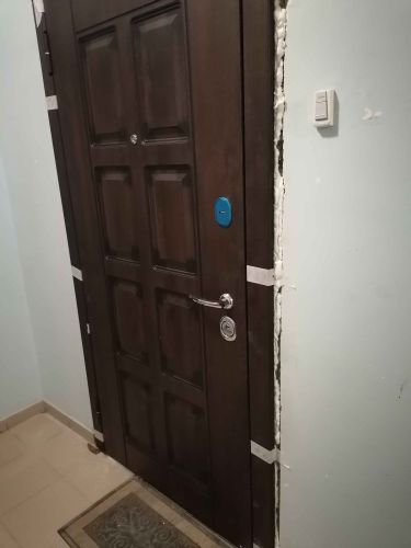 Установлена новая дверь, закреплена в проеме, зазоры заполнены монтажной пеной для изоляции. Проверена работа замка и ручки, проведена финальная регулировка для плавного закрывания.